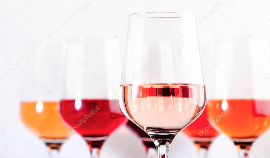 Rose wine glasses set on wine tasting. Different varieties, colors and shades of pink wines on white background