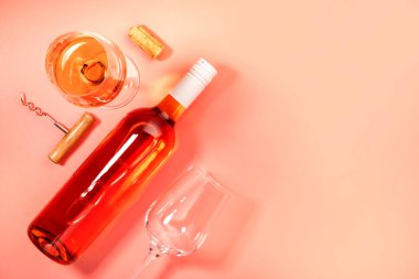 Pembe fırında şişeli gül şarabı kadehi. Rosado, rosato ya da kırmızı şarap tatma. Boşluğu kopyala, üst görünüm