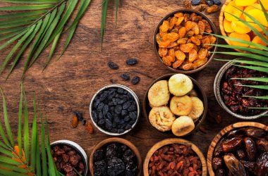 Sağlıklı yiyecek: kurutulmuş meyvelerin kurutulmuş organik karışımı: kayısılar, incirler, kuru üzümler, hurmalar ve diğer ahşap masa, üst görünüm