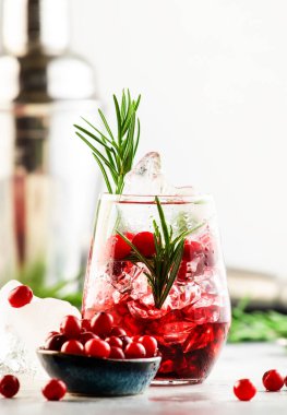 Kızılcık, votka, buzlu cin, biberiye ve bardakta böğürtlen. Yaz boyu içki. Gri tablo arkaplanı