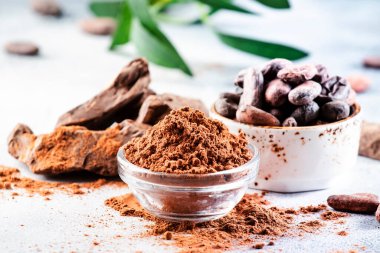 Organik kakao tozu, fasulye, gri arka planda rendelenmiş yumru. Boşluğu kopyala