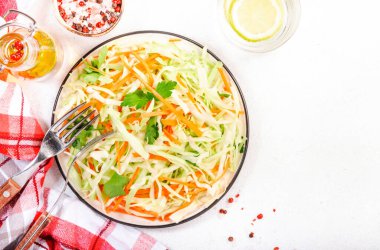 Lahanalı lahana salatası, beyaz mutfak masasında havuç. Üst görünüm, alanı kopyala