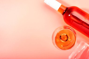 Pembe fırında şişeli gül şarabı kadehi. Rosado, rosato ya da kırmızı şarap tatma. Boşluğu kopyala, üst görünüm