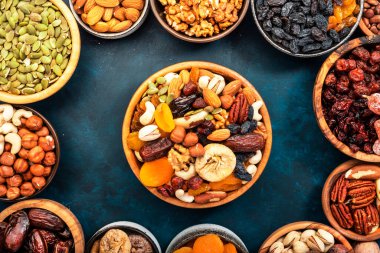 Fındık ve kurutulmuş meyve. Kurutulmuş kayısı, incir, kuru üzüm, ceviz, ceviz, fındık, badem ve diğerleri. Mavi arkaplan, üst görünüm