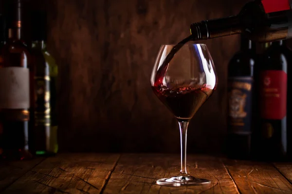 ワインの試飲 バラのワインをボトルに入れて木製の背景にガラスに注ぐ赤ワイン — ストック写真