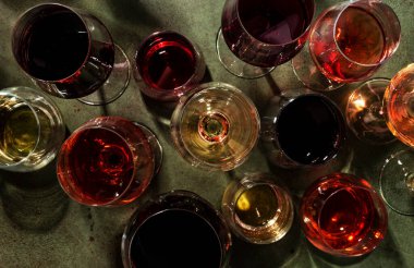 Kırmızı, gül ve beyaz şarap, paslı yeşil arka planda, üst manzara. Şarap barı, dükkan, şaraphane, şarap tatma konsepti. Sert ışık ve sert gölgeler