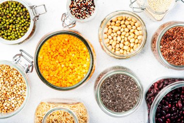 Grocery, home stocks in plastic free storage and jars. Various beans, grains, cereals, legumes, seeds in reusable cans. White table. Zero waste and sustanable lifestyle