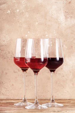 Bej masada gül şarabı bardakları. Rosado, rosato ya da kırmızı şarap tatma konsepti, negatif alan