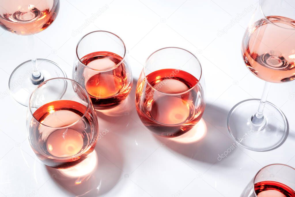 Rose wine of different shades in glasses on white background. Rosado, rosato or blush wines tasting