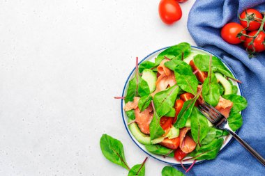 Somon avokado salatası, pancar yaprağı, radicchio, domates, keto için limon ve zeytinyağı sosu ve düşük kart diyeti. Gri arkaplan, üst görünüm