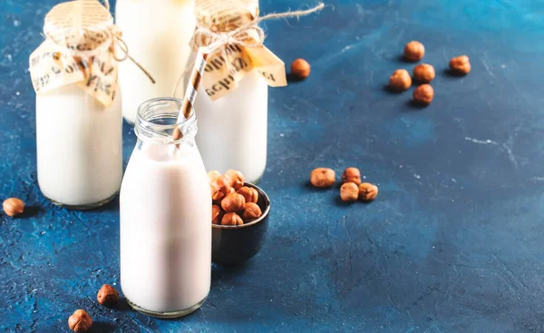 蓝桌背景上的山核桃牛奶 非乳制品替代纯素饮料 负空间 — 图库照片