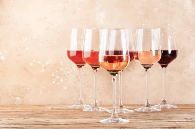 Bej masada gül şarabı bardakları. Rosado, rosato ya da kırmızı şarap tatma konsepti, negatif alan