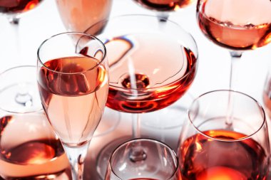 Beyaz arka planda farklı tonları olan gül şarabı. Rosado, rosato ya da allık şarabı tatma.
