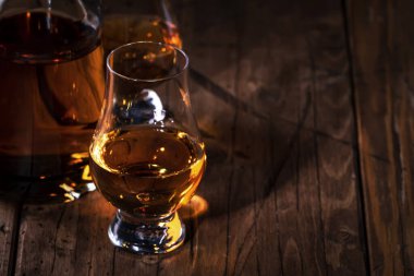 Özel bardaklarda viski, eski ahşap arka planda negatif alan.