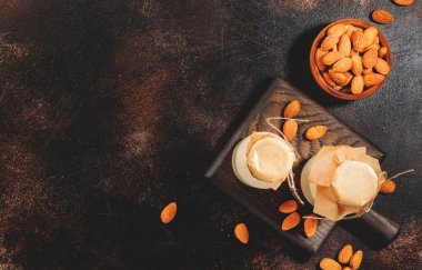 Kahverengi arka planda, badem sütlü bitkiler. Uzayı kopyala Üst görünüm