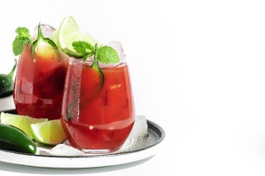 Votka, domates suyu, jalapeno biberi, buz, kireç ve tuz, beyaz arka plan, sert ışık, negatif boşluk