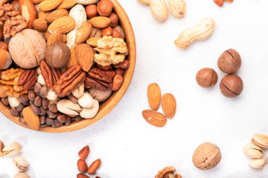 Kasede fındık karışımı. Badem, fındık, ceviz ve diğerleri. Sağlıklı yiyecek karışımı beyaz masa, üst görünüm, kopyalama alanı