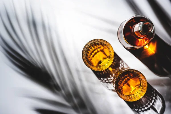 ガラスやボトルのアメリカのバーボンウイスキー 影のパターンと負のスペースを持つ白い背景 ハードライト — ストック写真