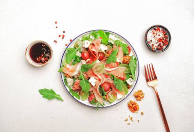 Prosciutto 'lu üzüm salatası, mavi peynir, roka, beyaz arka planda ceviz, üst manzara, kopyalama alanı