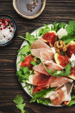 Prosciutto, mavi peynir, ceviz, roka, ahşap arka plan, üst manzara, kopyalama alanı