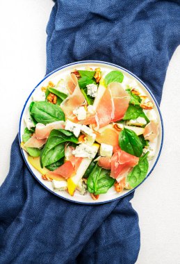 Prosciutto 'lu armut salatası, mavi peynir, ıspanak, beyaz arka planda ceviz, üst manzara, kopyalama alanı