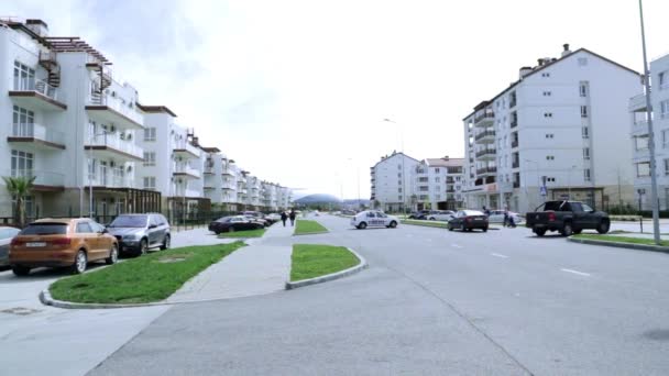 Sotsji. Adler. Olympic Park. Een rustige stad straat. Politie-auto. Taxi. Mooi weer. / B & b appartementen. Geparkeerde auto's. Gezellige stad. Witte huizen. — Stockvideo