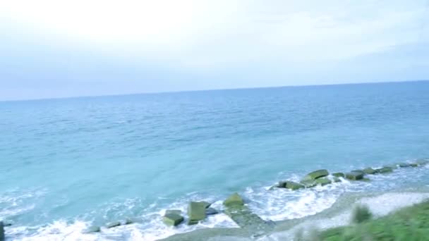列車の窓からの海の景色。黒海。青い海。電車の旅します。海への旅行。レジャー、旅行、観光。Rossyskie 鉄道。沿岸ストリップ。野生のビーチ. — ストック動画