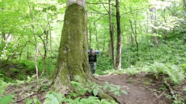 Ormanda yürüyen turist kadın. Ormanın içinde sırt çantası olan kadın. Hiking. Yeşil orman. bir tur orman. kamp. boş zaman. ekoturizm. Seyahate gitmek. vahşi. macera başlar. Engelleri aşmak. 