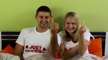 Yeni evliler nişan yüzüklerini yatağa göster. Genç gösteren alyans yatak odasında çift. Sadece evli, balayı, yeni evliler. Balayı, genç aile. 