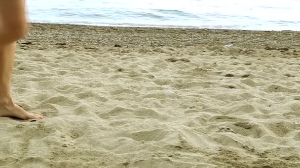 Los pies de las mujeres están en la arena. Una chica caminando por la playa. Arena, mar, hermosas piernas . — Vídeo de stock