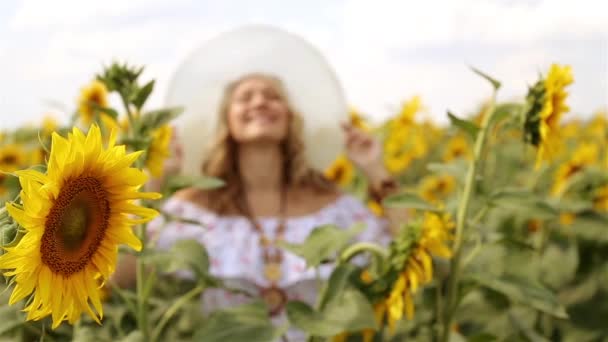 Vrouw onder zonnebloemen. Meisje in een veld met zonnebloemen. Vrouw die lacht in een veld met zonnebloemen. Zomer, natuur, zonnig weer. — Stockvideo