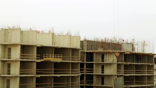 La grúa de construcción levanta la carga. Construcción de edificios de varios pisos. La grúa eleva la carga. Casa en construcción. Construcción de un edificio de varios pisos . — Vídeos de Stock