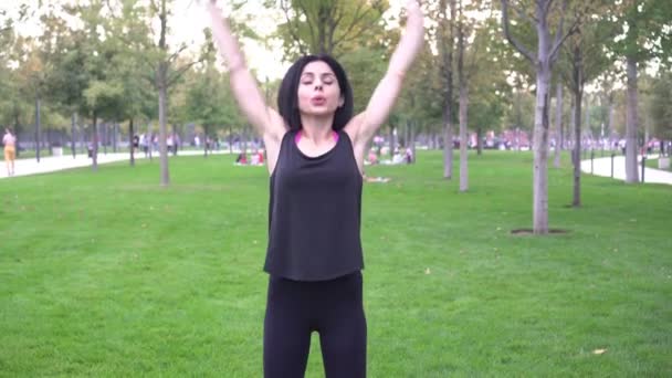 Mladá atraktivní žena se zabývá fitness v parku — Stock video