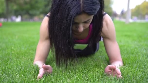 年轻的女运动员在公园里做跳板运动.运动员在大自然中从事健身活动 — 图库视频影像