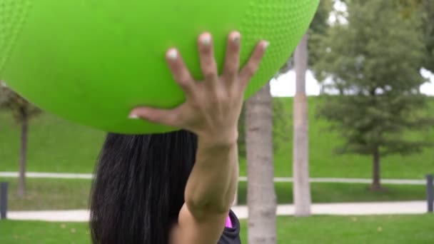 Mladá atraktivní žena se zabývá fitness s fit míč venku — Stock video