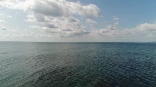 Fundo do mar bonito, calmo oceano azul e céu com nuvens baixas brancas — Vídeo de Stock