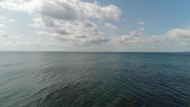 Piękne tło morza, spokojny niebieski ocean i niebo z białymi niskimi chmurami — Wideo stockowe