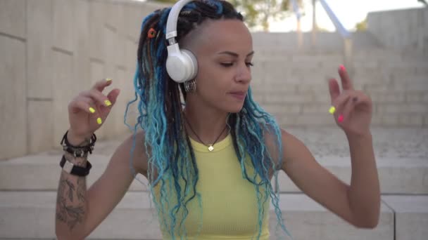 Modern, kentli çekici kadın kulaklıkla dışarıda müzik dinliyor. — Stok video