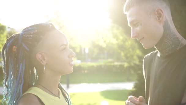 Portret van een prachtig modern romantisch jong echtpaar man en vrouw op de achtergrond van zonsondergang en zonnestralen — Stockvideo