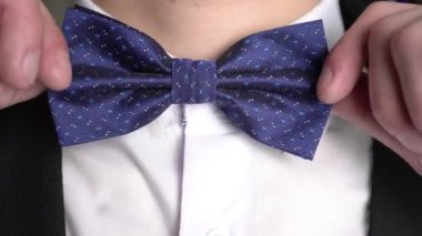 Papyonu yakın tut. Adam boynuna papyon takıyor. Klasik erkek modası..