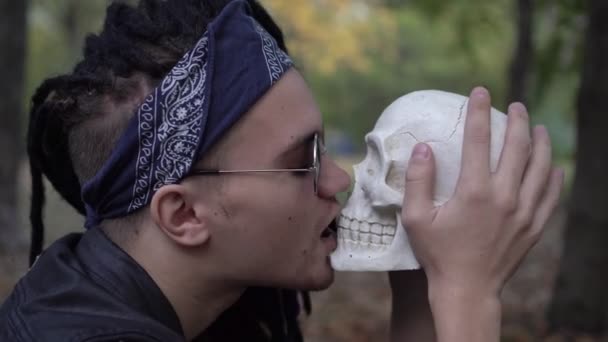 Неформальний панк-людина цілує людський череп — стокове відео