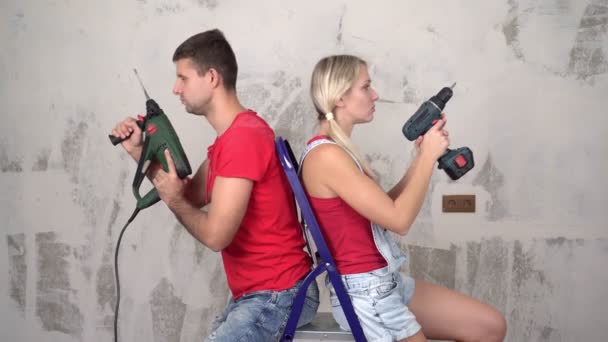 Portrait d'un jeune beau couple marié avec des outils de construction pendant la rénovation ou la construction de la maison — Video