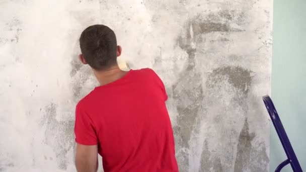 Um jovem faz reparos na casa e mostra um polegar para cima — Vídeo de Stock