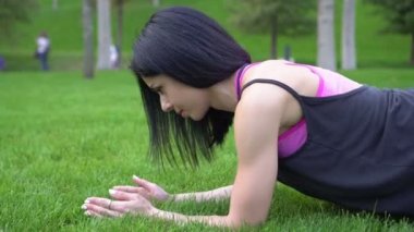 Sportif bir kadın spor yapıyor ve kalas egzersizi yapıyor.