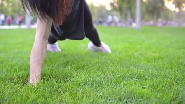 若い女性は草の上の公園でスポーツやフィットネスのために行く — ストック動画