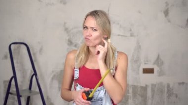 Kadın evi yenilemek için bir fikirle geldi. Evin arka planında mutlu bir kadının portresi.
