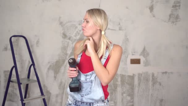Egy töprengő nő a lakásban végzett javítások hátterében. A személy gondolkodik, tükrözi a javítás során a házban. — Stock videók