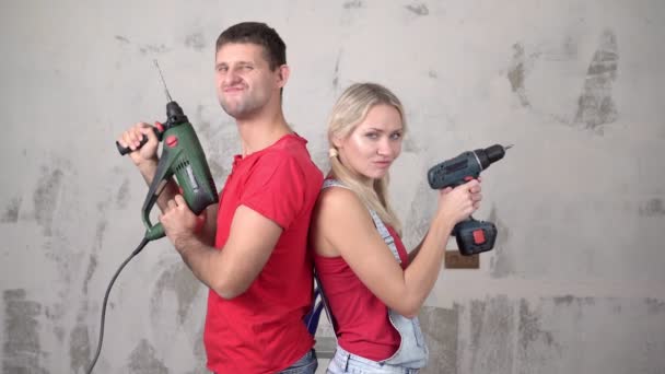 Jovem casal ou família com ferramentas de construção durante a renovação ou construção da casa. — Vídeo de Stock