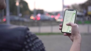 Bir adam şehir haritası ya da navigatörü olan bir akıllı telefon tutar.