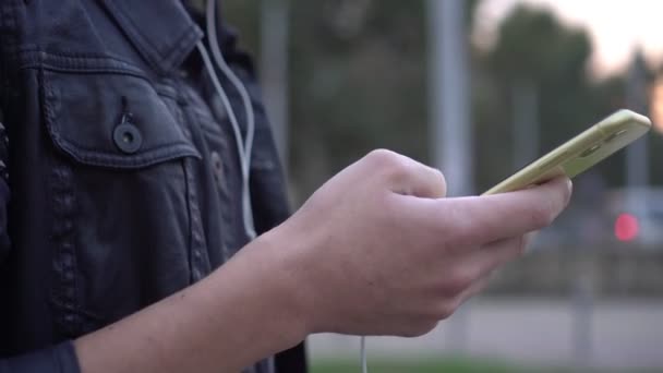 Un hombre al aire libre sostiene un teléfono inteligente y utiliza Internet, primer plano — Vídeos de Stock